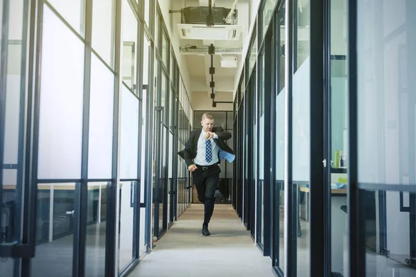 Biały biznesmen biegnący po korytarzu biurowym — Zdjęcie stockowe