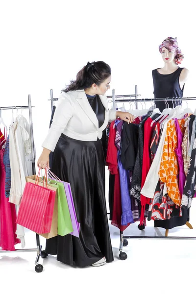 Şişman Asyalı kadın kıyafet seçimini yapıyor.