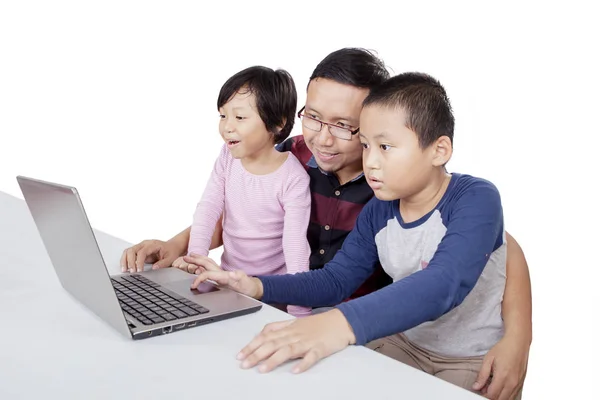 Hombre enseñando a sus hijos a usar una computadora — Foto de Stock