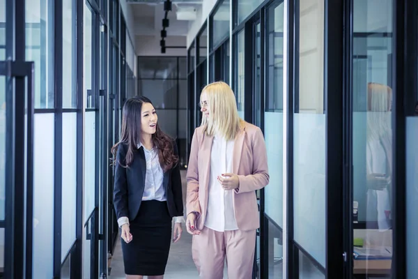 Portrait of women walking down the hallway happily — Stock Photo, Image