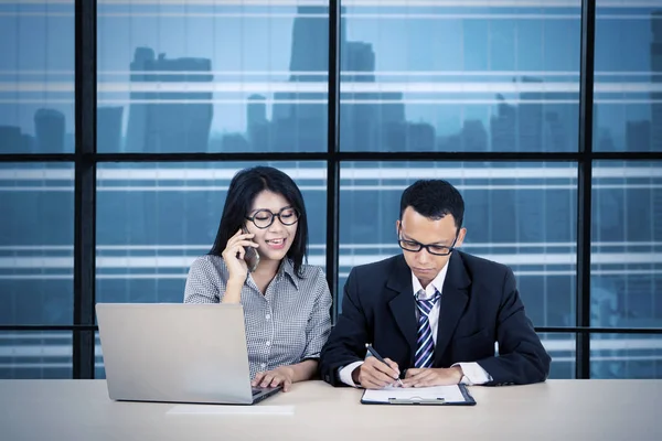 Mulher chamando enquanto supervisiona seu empregado — Fotografia de Stock