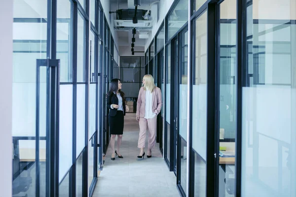 Kvinnor som pratar medan de går i korridoren — Stockfoto