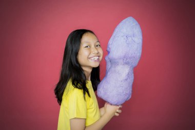 Elinde pamuk şeker tutarken kameraya gülümseyen çocuk