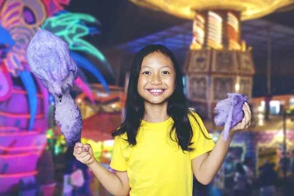 Adorable chica sosteniendo un caramelo y su parte en el parque —  Fotos de Stock