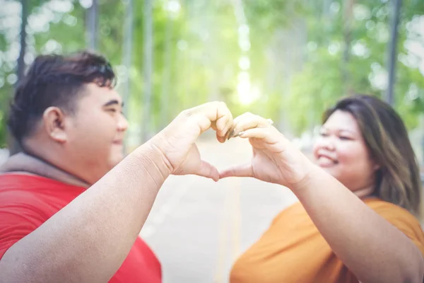 Szoros kép a kövér ázsiai pár csinál szerelem kéz jel — Stock Fotó