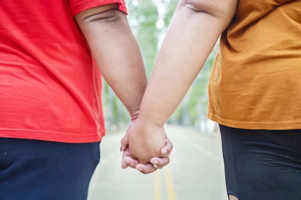 Närbild av oidentifierade feta par som håller händer — Stockfoto
