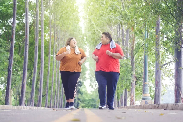 Tlustý asijské pár chatování šťastně při jogging — Stock fotografie