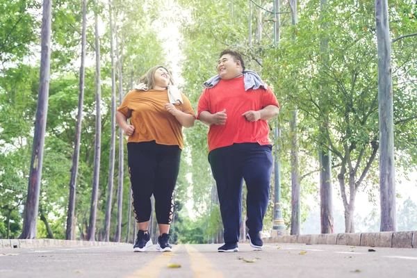 Fettes asiatisches Paar plaudert freudig unter den Bäumen — Stockfoto