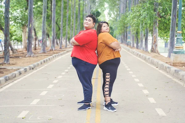 Fat Asian couple posing by crossing their arms — Stock Photo, Image