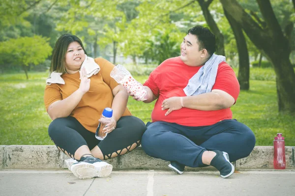 Fat Asian man offering water to his female friend — 스톡 사진