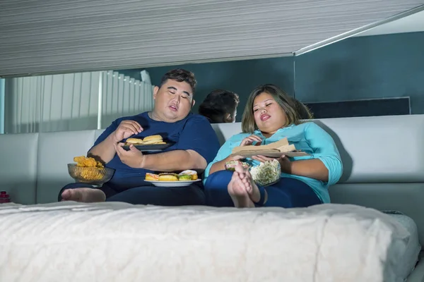 Coppia grassa mangiare cibi spazzatura mentre guarda la tv — Foto Stock