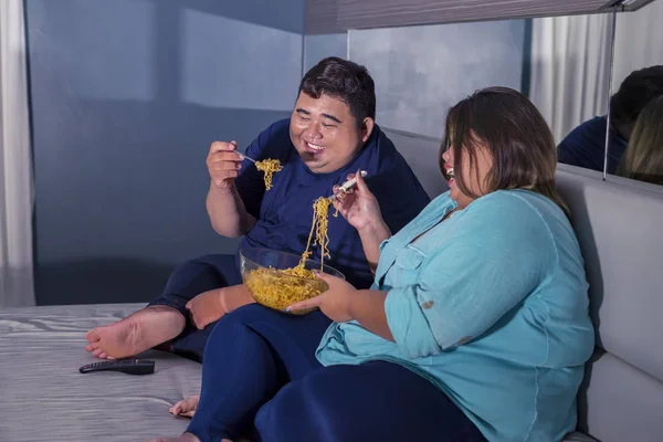 Fat couple laughing at some channel while eating — 스톡 사진