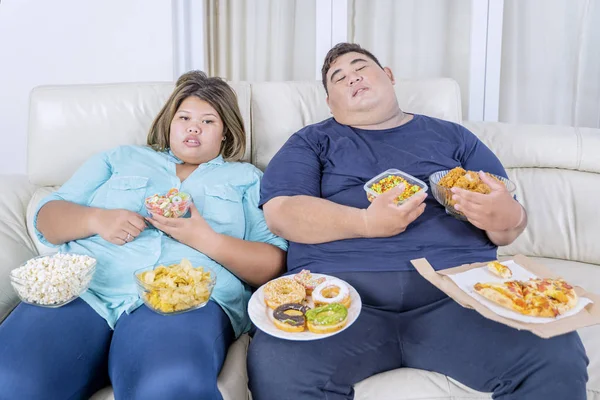 两对胖夫妇边吃饭边看电视 — 图库照片