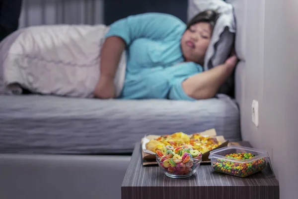 Wanita gemuk tidur sementara makanan cepat saji berbohong — Stok Foto