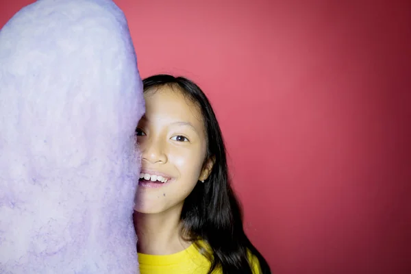 Menina aplaudindo e cobrindo seu rosto atrás de um doce — Fotografia de Stock