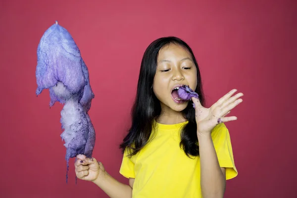 Meisje met een snoepje terwijl het eten van de gescheurde deel — Stockfoto