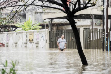Endonezyalı adam su birikintilerinden geçiyor