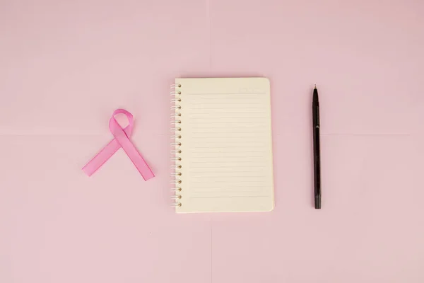 Colocação plana de fita rosa além de notebook e caneta — Fotografia de Stock