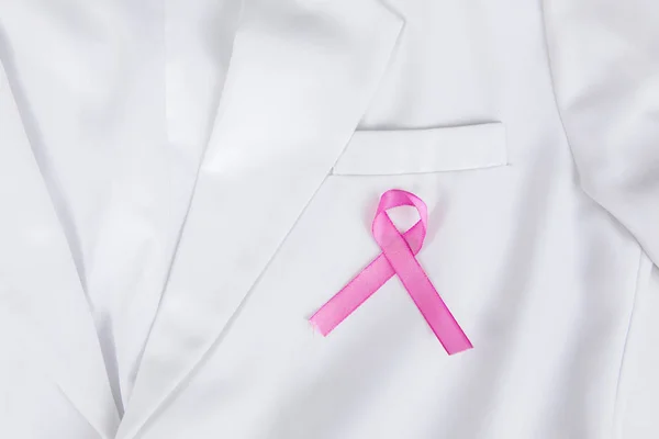 Pink ribbon attached to the pocket of lab coat — Stock Photo, Image