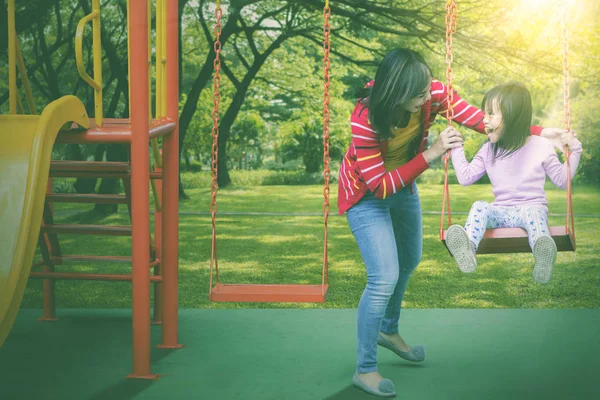 Vrouw kijken naar haar dochter swingen vreugdevol — Stockfoto