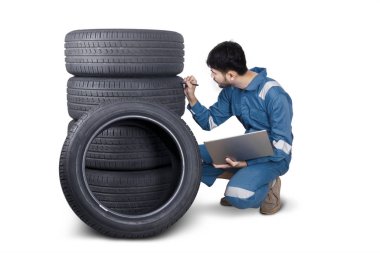 Tamirci stüdyoda lastik dokusunu kontrol ediyor.