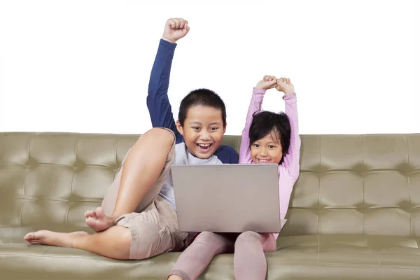 Adorable kids cheering while operating a laptop — Stock Photo, Image