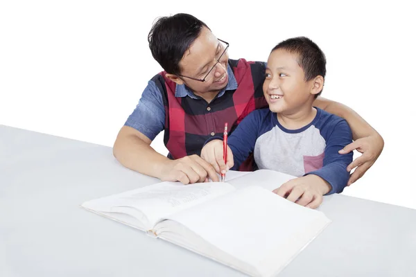 Az ember büszkén néz a fiára, miközben tanítja. — Stock Fotó