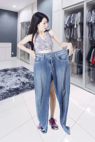 Mulher olhando para seus jeans com expressão chocada — Fotografia de Stock