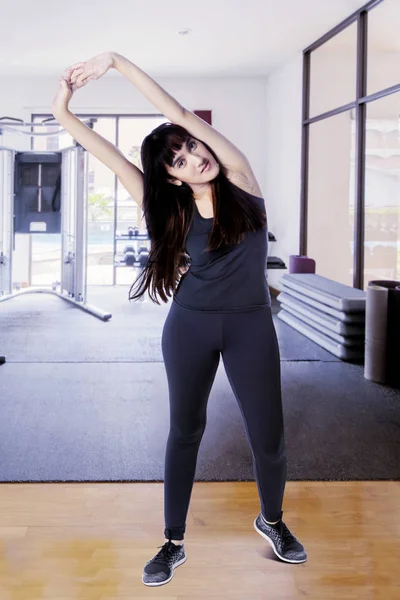 Femme étirant ses mains dans le centre de gymnastique — Photo