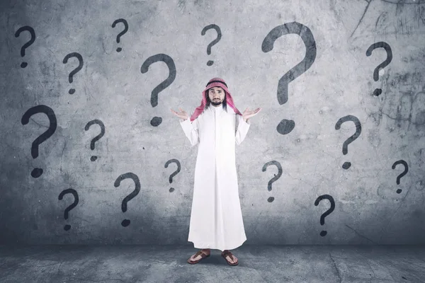 Hombre árabe confundido con signos de interrogación —  Fotos de Stock