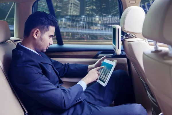 Hombre guapo apuntando su tableta en el coche — Foto de Stock