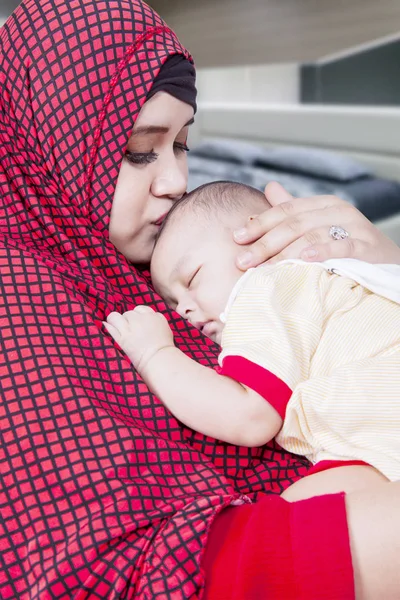 Szczęśliwa muzułmańska matka całuje swoje dziecko — Zdjęcie stockowe
