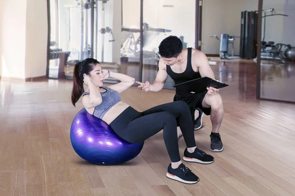 Man trainer tellen aziatische vrouw doen workout — Stockfoto