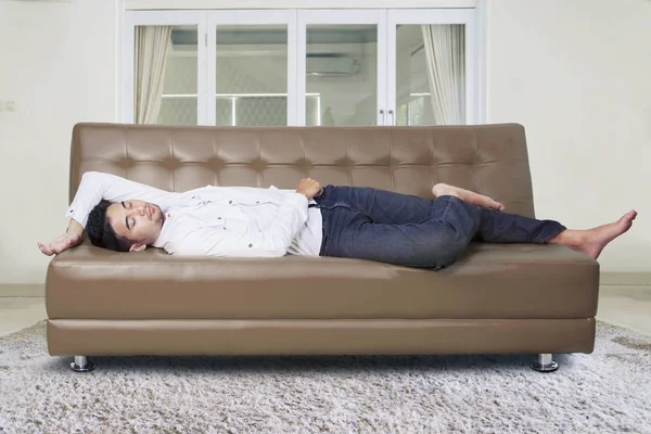 Homem dormindo no sofá na sala de estar — Fotografia de Stock