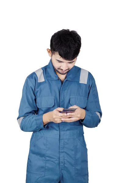 Mechanic using a mobile phone in the studio — Stock Photo, Image