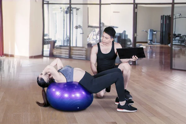 Personlig instruktör som hjälper unga kvinnor att motionera — Stockfoto