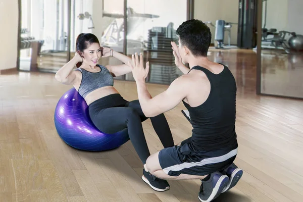 Personal trainer helpen jonge vrouw doen workout — Stockfoto