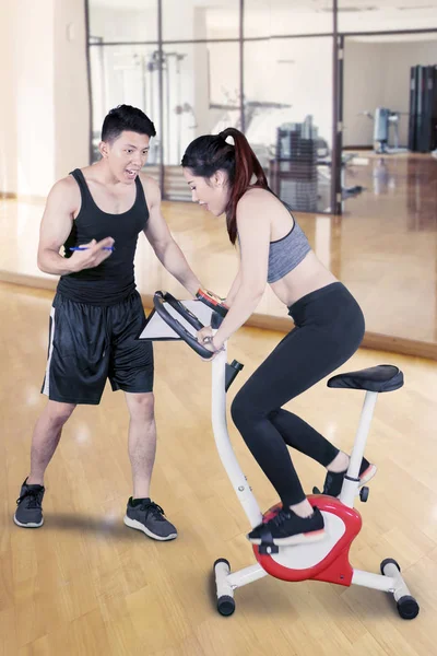 Woman riding a spinning exercise bike at gym — 스톡 사진