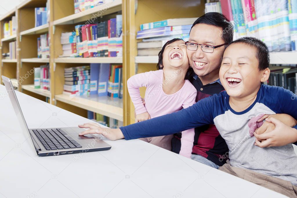 Cheerful children studying with their father
