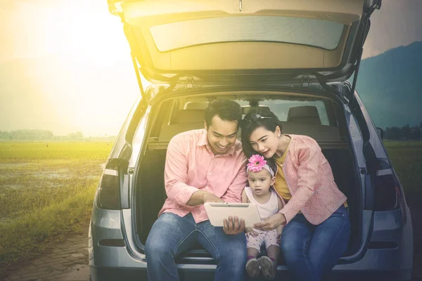 Parents et enfants regardant la tablette en voiture — Photo