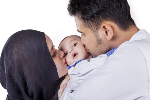 Genç ebeveynler battaniyenin altında bebeklerini öpüyor — Stok fotoğraf
