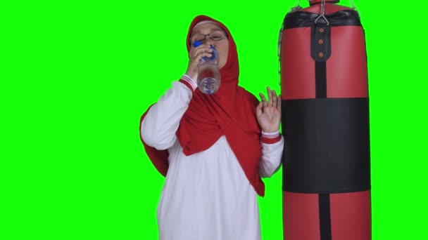 Reife Muslimische Frau Trinkt Wasser Der Nähe Von Boxsack Video — Stockvideo