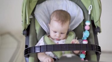 Bebek arabasında oturan sevimli kız bebek, video.