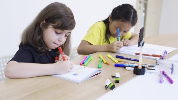 Due Bambine Che Scrivono Sul Libro Con Pastelli — Video Stock