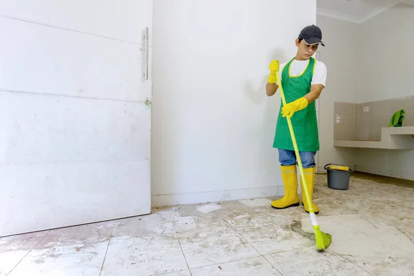 亚洲工人清扫肮脏的地板 — 图库照片