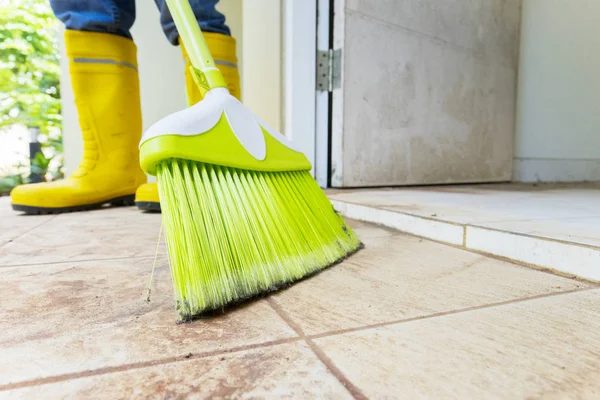 Fechar o trabalhador masculino limpando o chão com uma vassoura — Fotografia de Stock