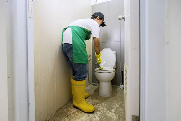 Männliche professionelle Reinigungskraft säubert einen dreckigen Toilettensitz — Stockfoto