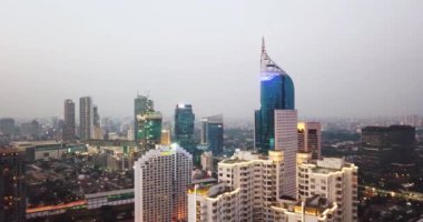 JAKARTA, Indonesia - February 14, 2020: Beautiful aerial view of BNI tower with misty Jakarta cityscape at morning time. Shot in 4k resolution from a drone flying spinning around