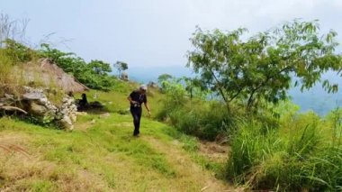 Üst düzey bir adam tepede dijital bir kamerayla doğa fotoğrafı çekiyor. 4k çözünürlükte çekiliyor