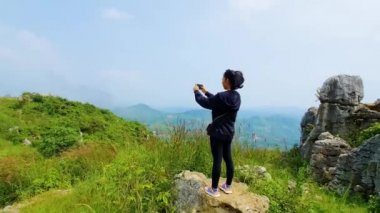 Kadın akıllı telefonuyla doğa fotoğrafı çekiyor.